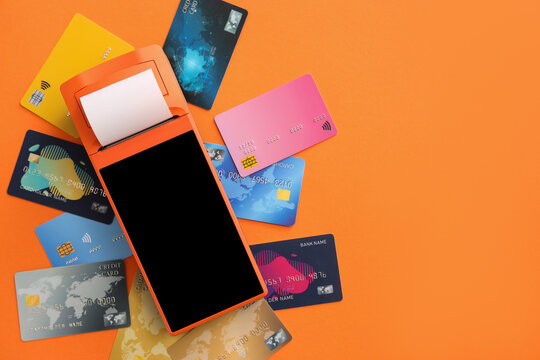 Payment terminal with credit cards on orange background
