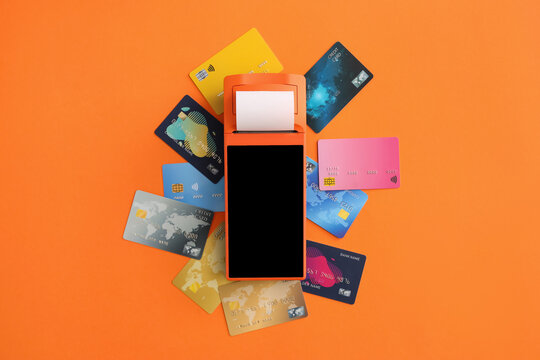 Payment terminal with credit cards on orange background