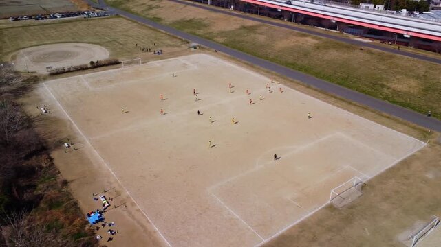 土手でサッカーをする少年たちを空撮　4K