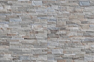 Obraz premium Beige and gray stoneware paneling wall with stone effect. Background and texture.