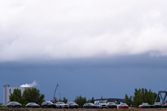 Overcast storm weather as heavy clouds fill the sky above horizon parking and cars in Hamburg Germany creating a dramatic moody scene