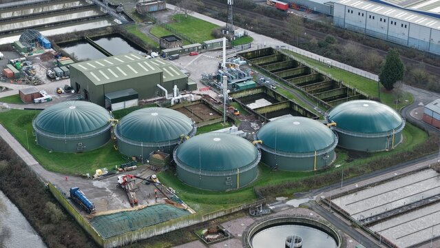 Aerial view of the Severn Trent Water treatment plant, where the green, dome-shaped digesters contrast with the industrial buildings, Coleshill, United Kingdom.