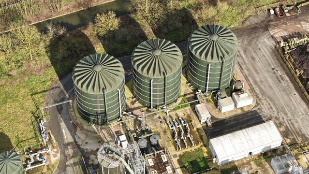 Aerial view of colossal, cylindrical tanks casting stark shadows on the industrial landscape, Severn Trent Water, Coleshill, United Kingdom.