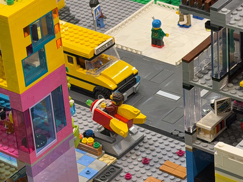 Lego city street with yellow bus and colorful buildings