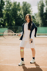 Obraz premium Young woman playing tennis on a clay court