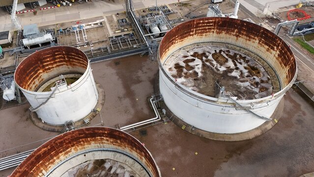 Aerial view of weathered tanks amidst a network of pipes and industrial structures at Kingsbury Oil Terminal, Tamworth, United Kingdom.