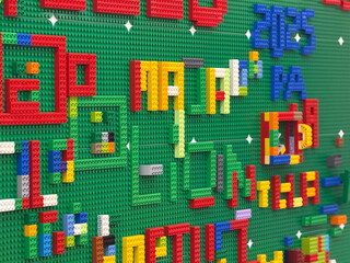 Naklejka premium Colorful lego letters on green baseplate