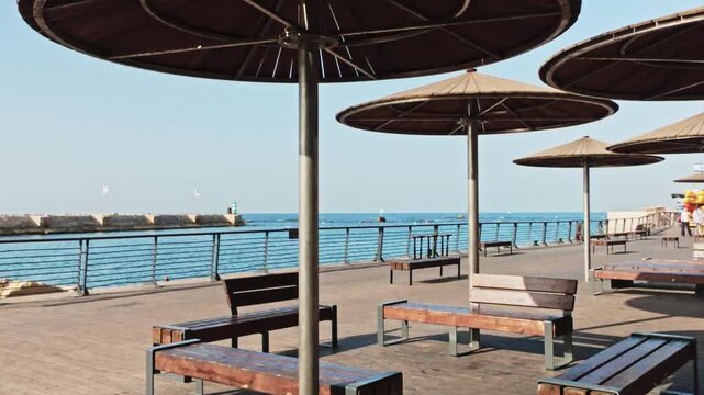 Wooden Parasols And Benches On Jaffa Port Promenade By The Sea