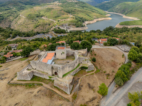 Aerial view of the Lindoso Castle, a medieval fortress standing proudly atop a hill overlooking the tranquil Alto Lindoso reservoir, Lindoso, Viana do Castelo District, Portugal.