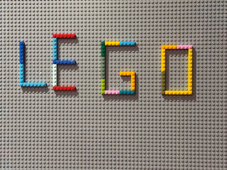 Naklejka premium Colorful lego bricks spelling 'lego' on gray baseplate