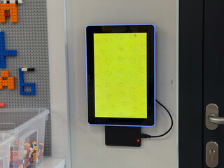Naklejka premium Wall-mounted tablet kiosk with yellow display
