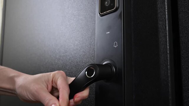 A woman opens a modern smart door lock using a contactless key.