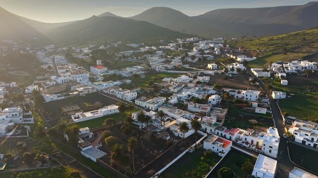 Aerial view of Haria village in Lanzarote at sunrise, traditional white houses and palm trees in the valley of thousand palms. Beautiful morning panorama of Haria town in Canary Islands 