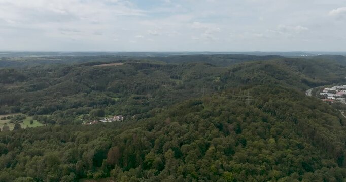 Wide Aerial View of Lush Green Forested Hills and Mountains in St. Ingbert Saarland, Panoramic Landscape of Central European Woodland with Small Village Houses under a Cloudy Summer Sky