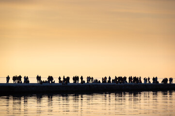 Fototapeta premium People on molo audace at sunset in triest, italy