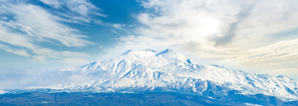 great amazing mountain peak in white winter snow with beautiful blue cloudy sky on background