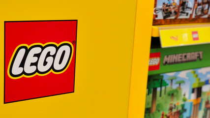 Naklejka premium Close up of iconic red and white Lego logo sign on a yellow shelf in a retail toy store on January 3, 2025 in Bangkok, Thailand.