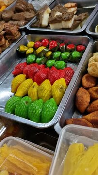 Pan right of various types of colorful Malay dishes (kueh muih) sold at local markets during Ramadan month. 