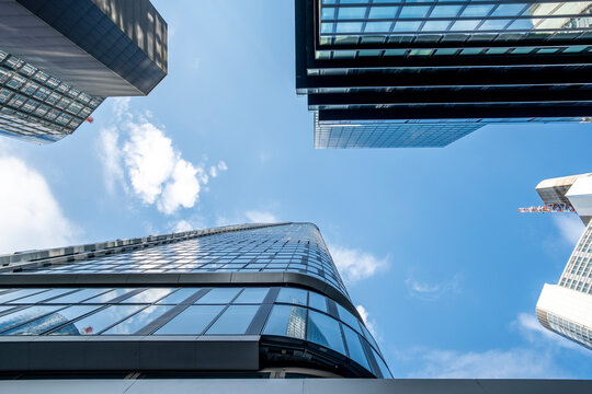 Modern glass skyscrapers architecture rising upward in the financial district of Frankfurt Germany under clear sky with strong city lines