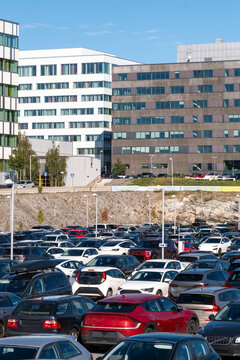 Cars in parking with traffic shaping urban city transport commute past modern buildings in Stockholm Sweden during daylight travel