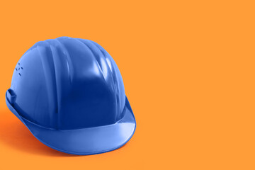 Fototapeta premium Blue hardhat on orange background