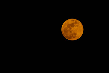 Obraz premium Landscape with the red full moon of March 3, 2026 before the eclipse positioned in one third of the image