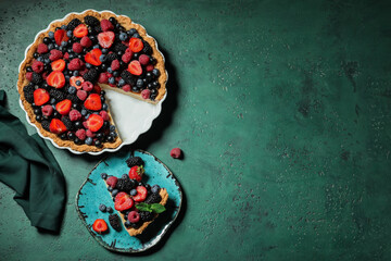 Obraz premium Cut delicious berry pie on green grunge background