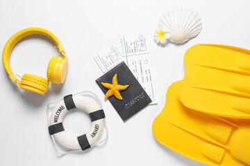 Composition with seashell, headphones, flippers and passport with tickets on white background, closeup © Pixel-Shot