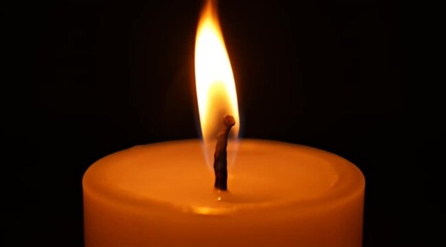 Ethereal Glow A Single Candle Flame Radiating Warmth Against the Darkness