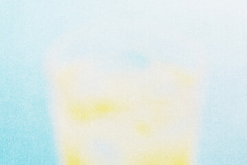 ざらざらの紙とぼやけたオレンジジュースの画像