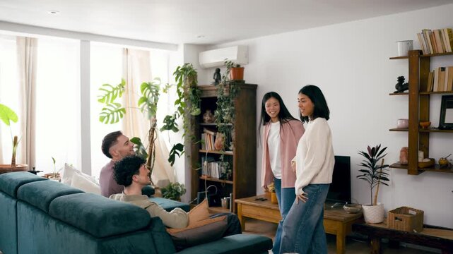 Cheerful young friends gathering at home for a fun party. Diverse people playing charades and gesturing while laughing in a cozy living room