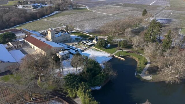 Chateau Lagrange, France - 06 January 2026: Aerial view of the snow-dusted Chateau Lagrange Est, with its elegant architecture and serene lake.