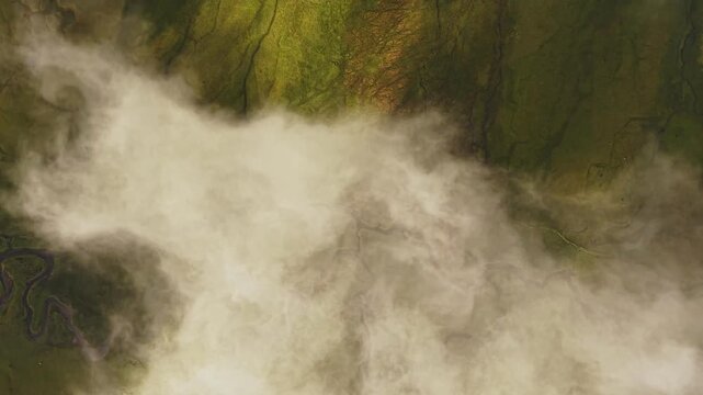 Aerial view of Phobjikha Valley with a winding river amidst a blanket of low-lying clouds casting shadows on the landscape, Nubding, Bhutan.