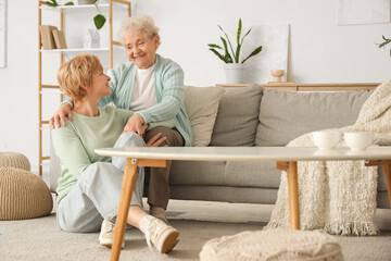Obraz premium Senior woman hugging her daughter at home. Mother's Day celebration