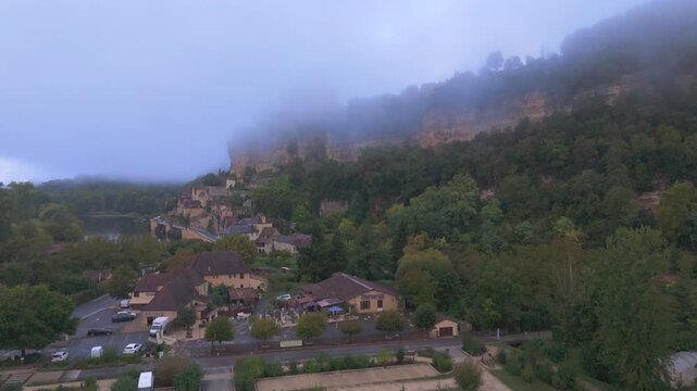 Beynac-et-Cazenac, France - 12 September 2025: Aerial view of Chateau de Beynac piercing through a sea of ethereal mist, a medieval fortress.