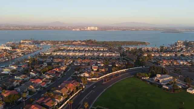 Aerial view of the Coronado Cays Bridge casting shadows over the water and houses, blending into the landscape, Coronado, California, United States.