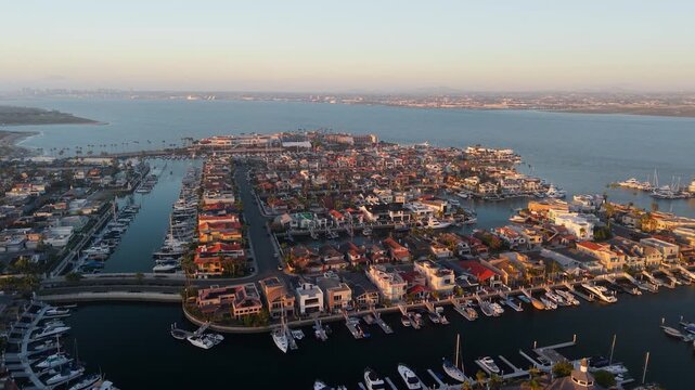 Aerial view of Coronado Cays, a residential community with many boats docked along canals reflecting the warm sunlight, Coronado, California, United States.