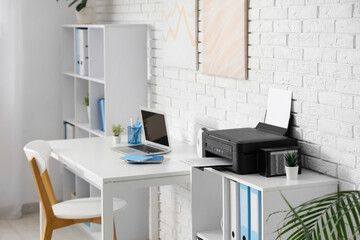 Shelving unit with modern printer and folders in light home office