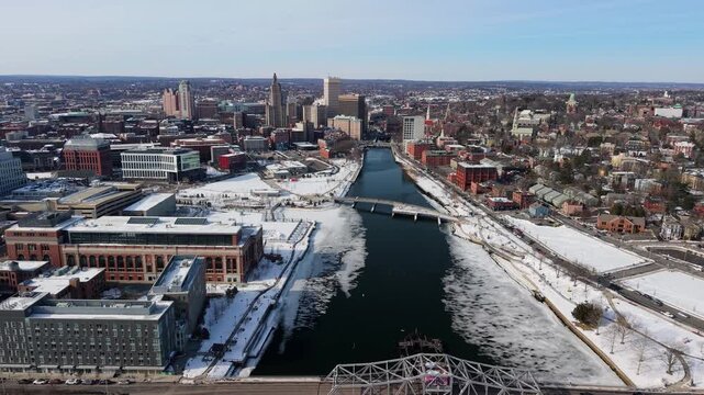 Aerial view of the Providence river with buildings and bridges, showcasing the city's winter landscape with snow-covered grounds, Providence, Rhode Island, United States.