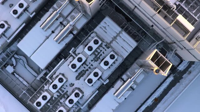 Aerial view of a rooftop of a modern data center with its advanced cooling and ventilation systems covered in snow, Warszawa, Poland.