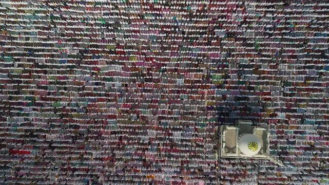 Aerial view of a multitude of people closely gathered, creates a textured mosaic of colors and patterns, Malda, West Bengal, India.