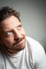 Fototapeta premium Man with Curly Hair and Beard Looking Upward to the Side