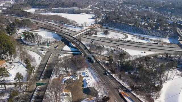 Aerial view of Interstate 95, showcasing a stark contrast between snow-covered landscapes and busy roads, Salisbury, Massachusetts, United States.