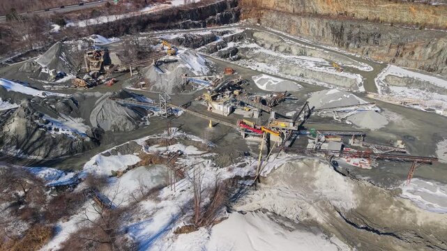 Aerial view of a quarry, contrasting the stark grey of the stone with the white snow, creating a scene of industrial activity, Cumberland, Rhode Island, United States.