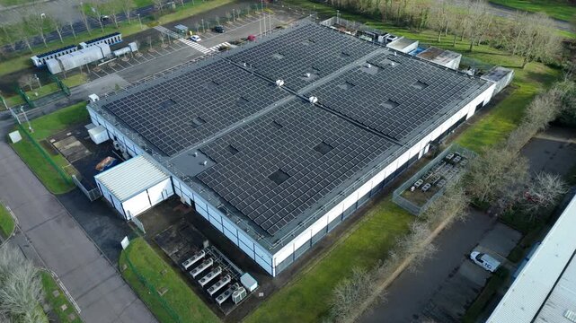 Aerial view of a modern data centre, its roof covered in solar panels, contrasting with the green surroundings, Milton Keynes, Milton Keynes, United Kingdom.