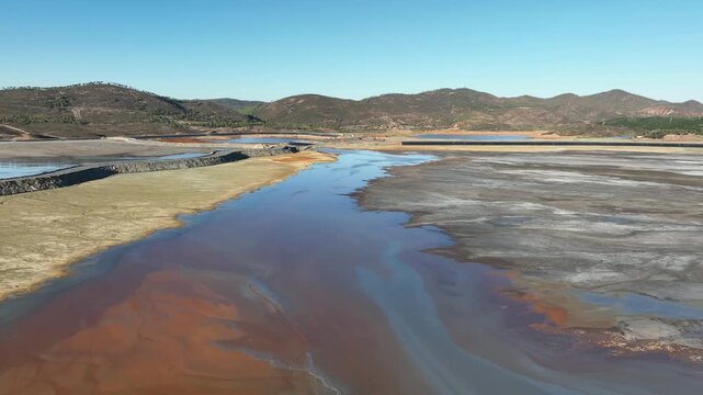 Aerial view of the vividly colored Rio Tinto river, a surreal landscape of contrasting red and grey textures, Minas de Riotinto, Andalusia, Spain.