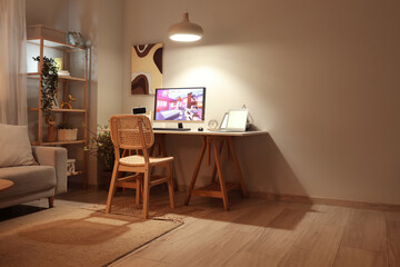 Obraz premium Computer with launched video game on table in stylish living room at evening