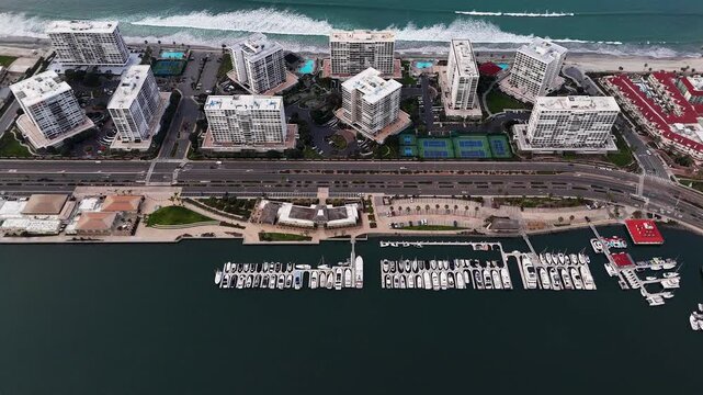 Aerial view of buildings near the beach, showcasing the contrast of white buildings against the blue ocean, Coronado, California, United States.