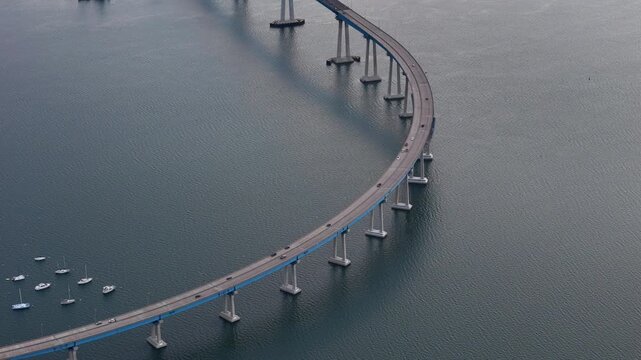 Aerial view of the Coronado Bridge spanning across the dark waters with boats sailing underneath, Coronado, California, United States.