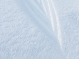 Beautiful winter background with snowy ground. Natural snow texture. Wind sculpted patterns on snow surface. Arctic, Polar region.